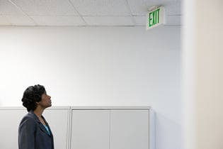 Woman looking up at exit sign