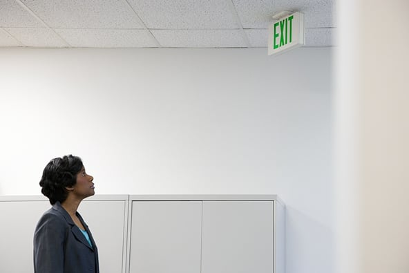 Woman looking up at exit sign