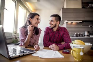 Two smiling retail owners discussing finances