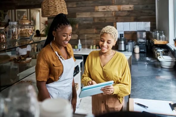 Two women using AI on an iPad