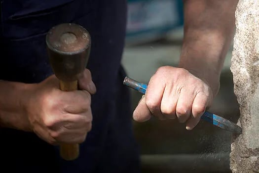 Hands chiseling stone