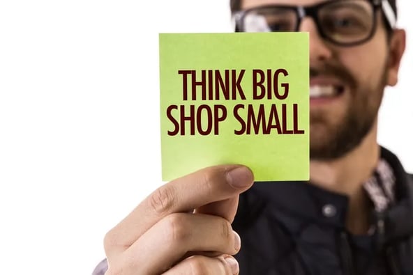 Man holding sign Think Big Shop Small