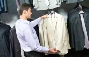 Man looking at suit jacket in retail store